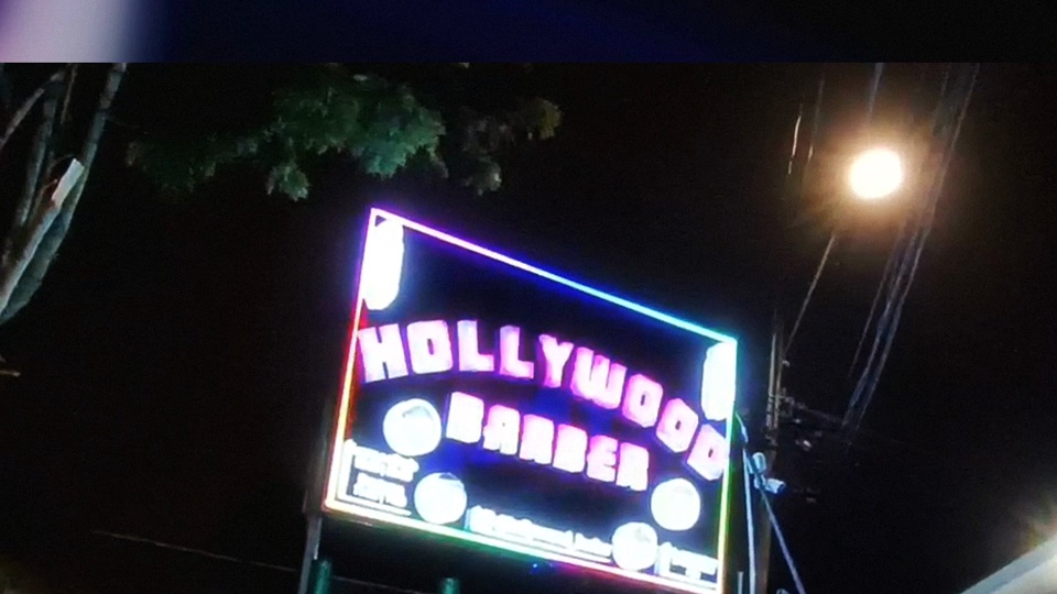 Letrero de Hollywood Barber encendido de noche